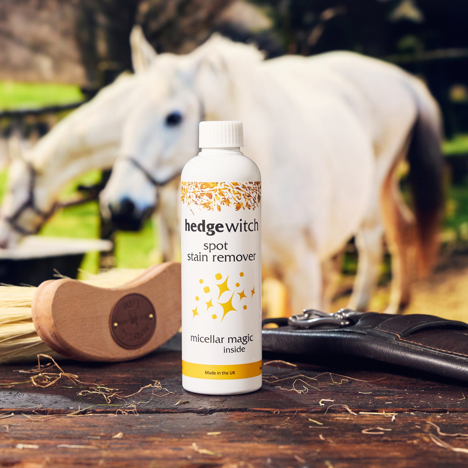 white bottle with gold 'hedgewitch' hedge branding with grey horses in the backround