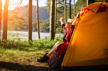 A lady enjoying camping by a loch